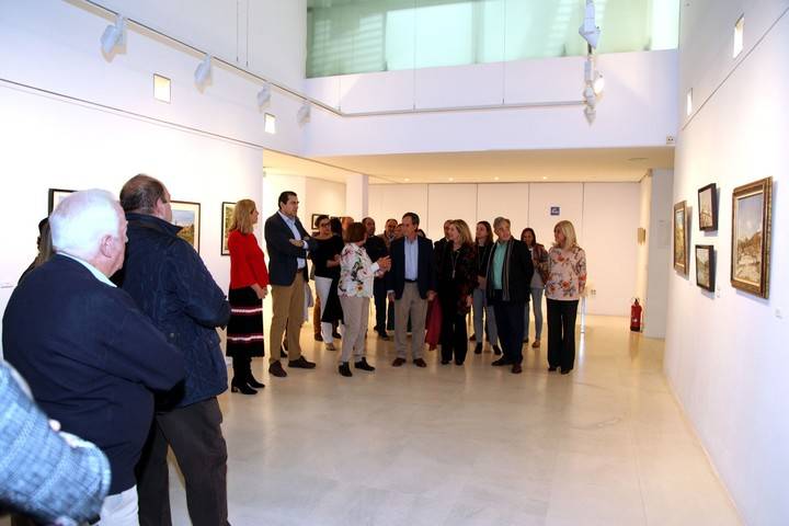 Imagen de la inauguración de la exposición  'Guadarrama, naturaleza y paisaje a través del tiempo', donde la autora les explica al alcalde de Alcobendas y demás asistentes las trazas principales de su exposición