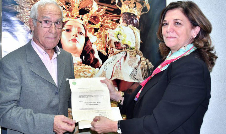 Foto realizada por la Hermandad de La Paz y que retrata el momento en el que Isabel Páramo, Presidenta de la Hermandad, le entrega a Luis Martín Melendro el documento que lo acredita como Prioste Mayor de las Fiestas de este año